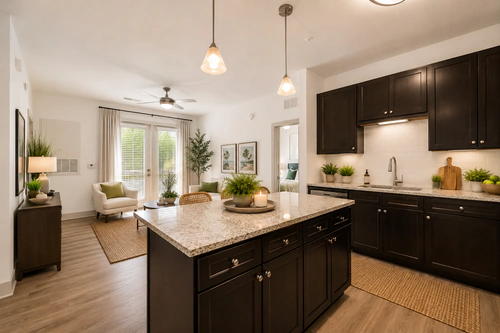 Millennium Apartments' kitchen with a granite island opening onto the living room
