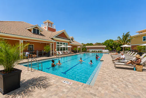 Residents swimming in the resort style lap pool beside the Millennium Apartments clubhouse