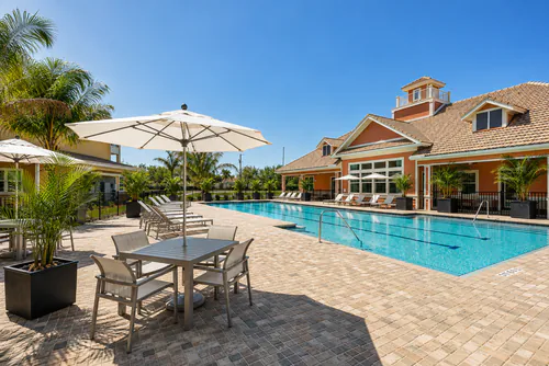 Shaded patio seating on Millennium Apartments' pool deck